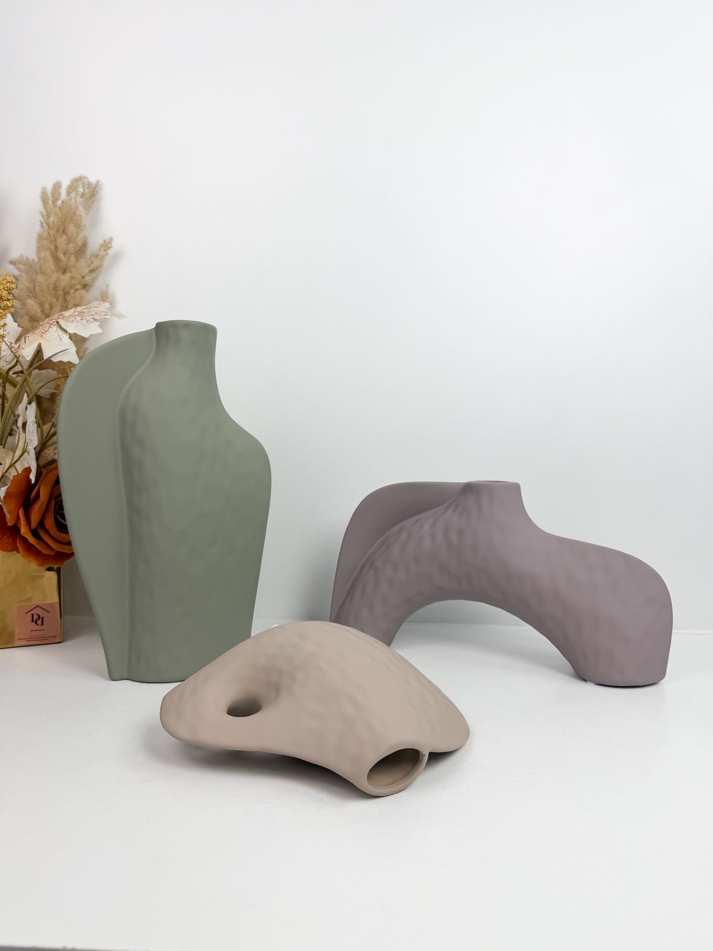 Trois vases décoratifs en céramique aux formes abstraites et aux couleurs neutres