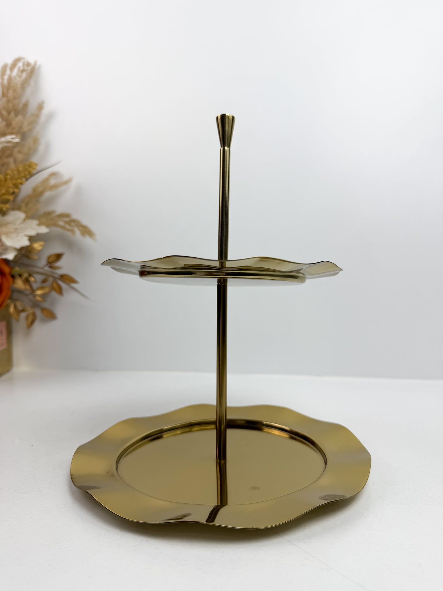 Plat de service ou présentoir à gâteaux 2 étages doré avec des bords festonnés.