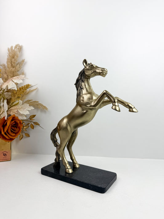 Statue de cheval cabré en résine avec une finition bronze sur un socle noir.