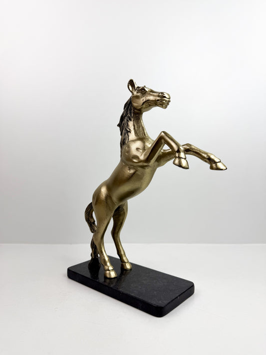 Statue de cheval cabré en résine avec une finition bronze sur un socle noir.