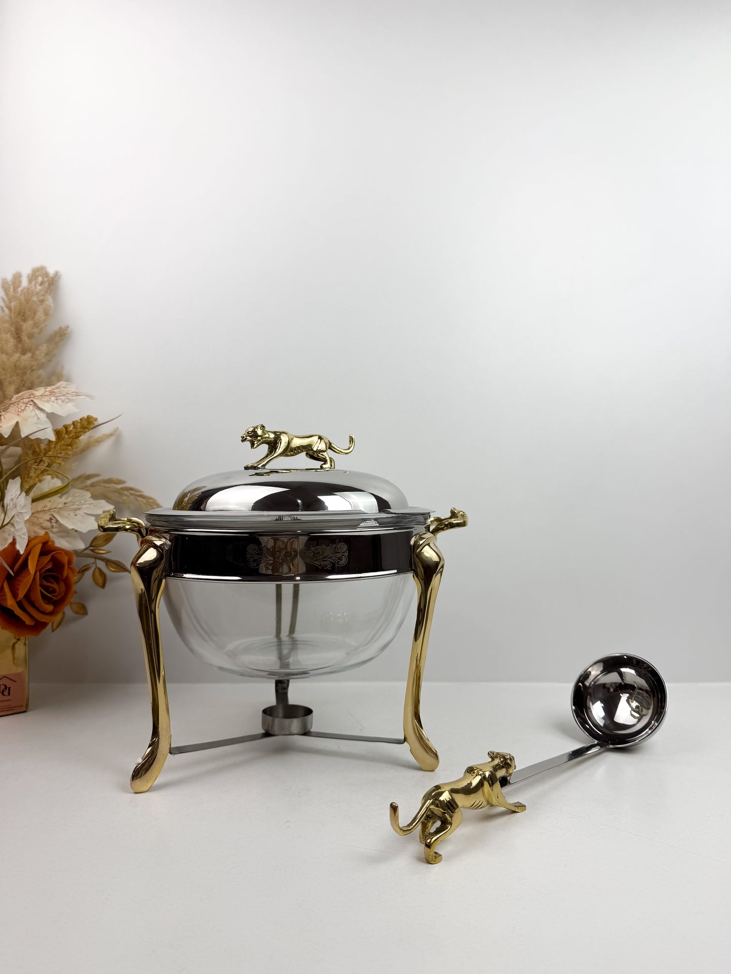 Soupière chauffe-plat en acier inoxydable et des figurines de panthère sur le couvercle et la louche.