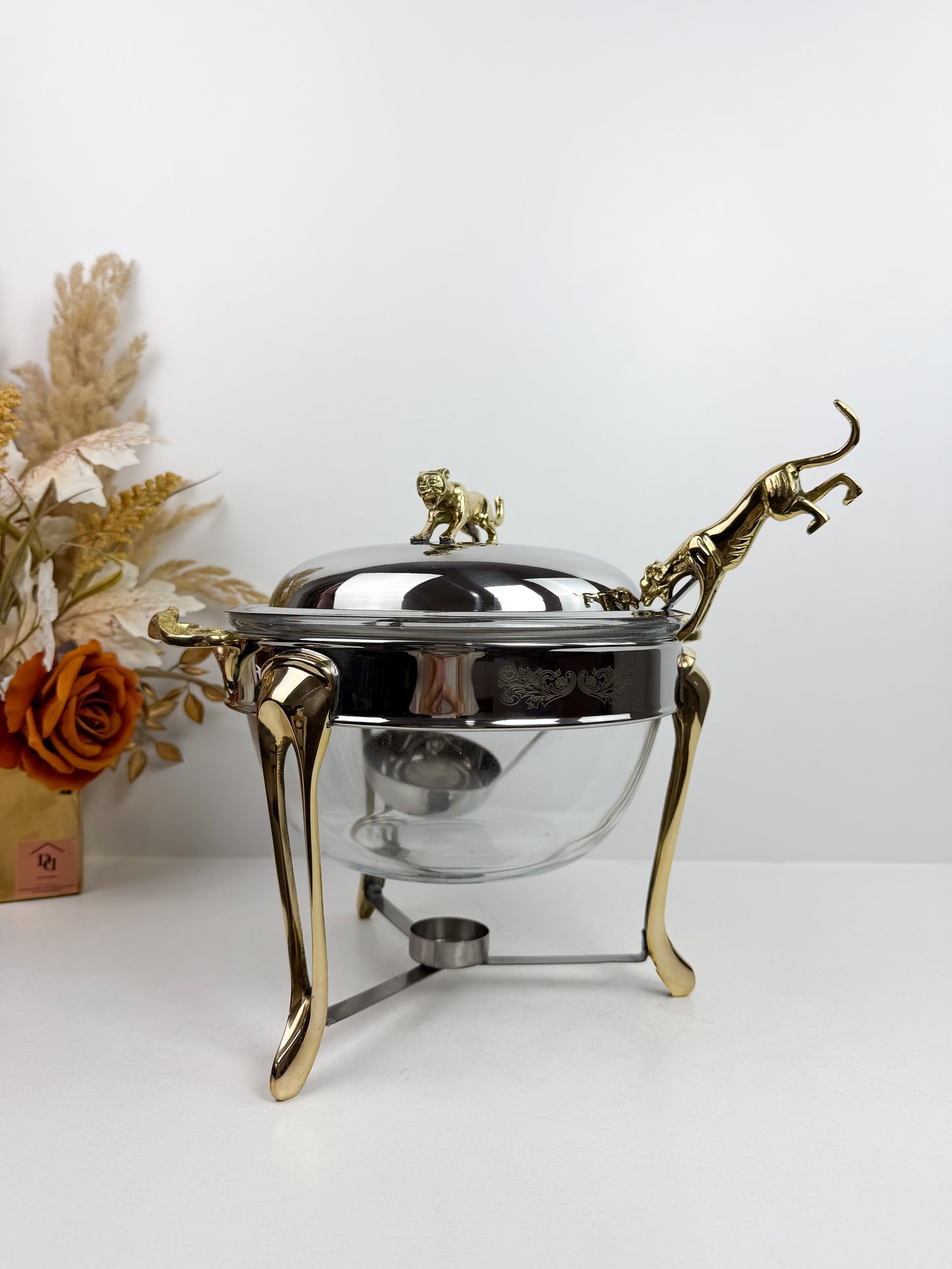 Soupière chauffe-plat en acier inoxydable et des figurines de panthère sur le couvercle et la louche.