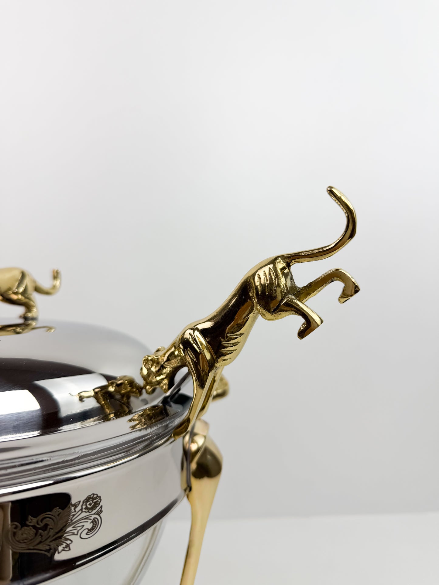 Soupière chauffe-plat en acier inoxydable et des figurines de panthère sur le couvercle et la louche.