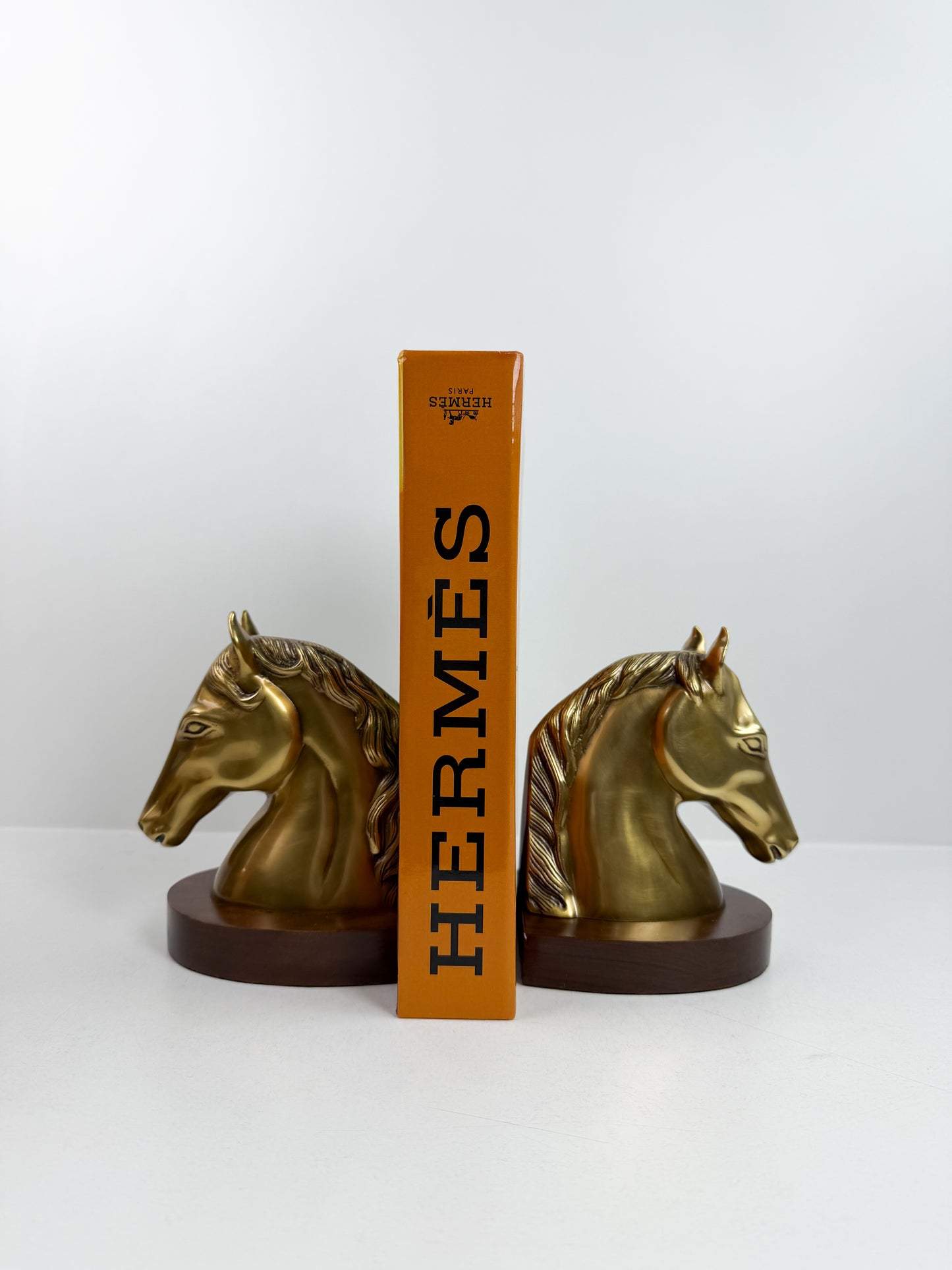 Paire de serre-livres en forme de tête de cheval en cuivre.