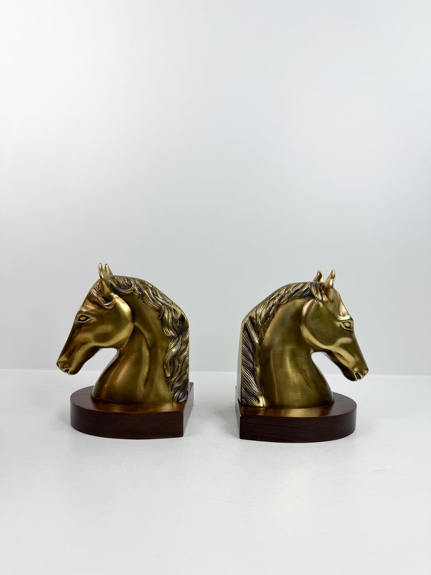 Paire de serre-livres en forme de tête de cheval en cuivre.